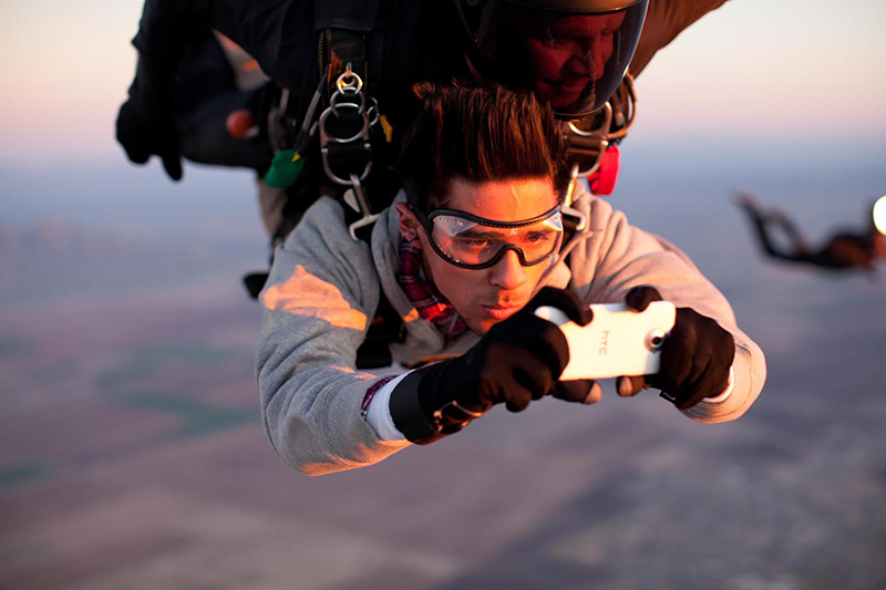 Skydiver holding a phone during freefall